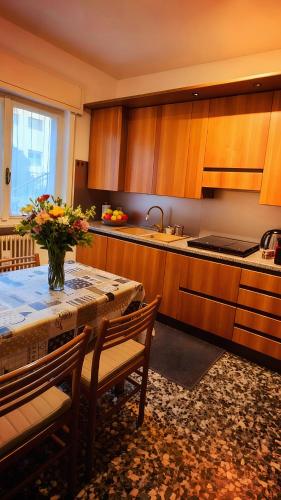 a kitchen with a table with a vase of flowers on it at Villa dei Pini in Laveno-Mombello