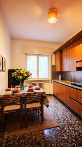 a kitchen with a table with a vase of flowers on it at Villa dei Pini in Laveno-Mombello
