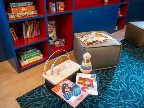 a childs play area with a toy box and books at Aparthotel Adagio Paris Malakoff Chatillon in Malakoff