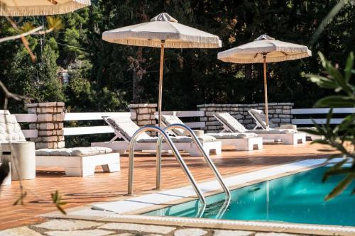 uma piscina com cadeiras e guarda-sóis ao lado de uma piscina em Myrto Homes Lefkada Agios Nikitas Greece em Ayios Nikitas