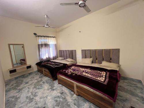 a bedroom with two beds and a mirror at Maharaja hotel and dhaba in Roorkee