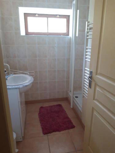 a bathroom with a sink and a toilet and a window at Gîte de la source in Cassagnes