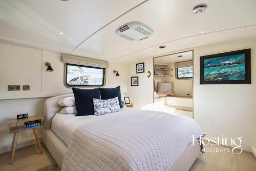 1 dormitorio con 1 cama grande en un barco en The Pemberley - Luxury 2 Bed Houseboat, en Londres