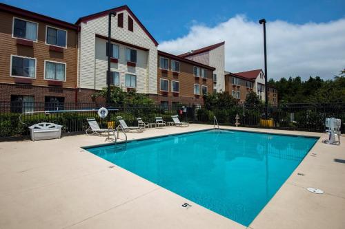 a swimming pool in front of a apartment complex at Red Roof Inn & Suites Savannah Airport in Savannah