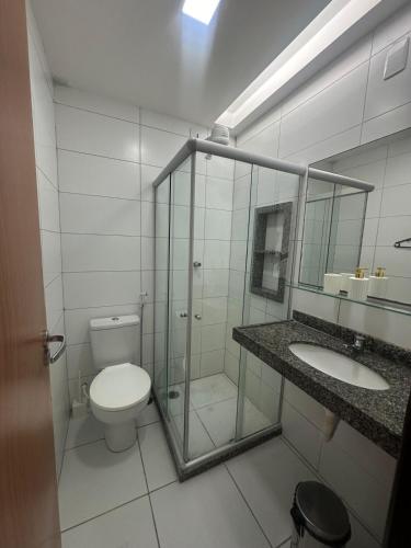 a bathroom with a toilet and a shower and a sink at Monte Castelo Flat Temporada in Bezerros
