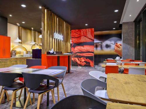 un restaurant avec des tables, des chaises et un comptoir dans l'établissement Ibis Gdansk Stare Miasto, à Gdańsk