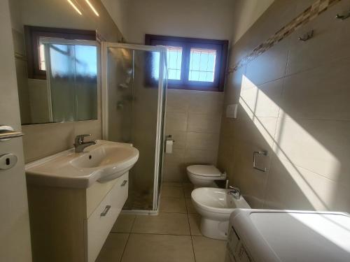 ein Badezimmer mit Waschbecken, Toilette und Dusche in der Unterkunft Residence Equilio Family Apartments in Lido di Jesolo