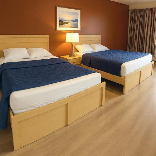 a hotel room with two beds and a lamp at Inn On Pim in Sault Ste. Marie