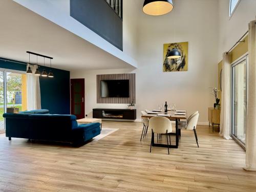 Una sala de estar con un sofá azul y una mesa. en VillasHomeClet - Villa Côte & Lac, en Naujac-sur-Mer