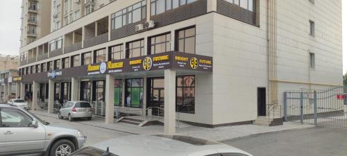 a building on a city street with cars parked outside at Action Djal in Bishkek