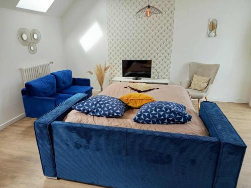 a blue bed with pillows on it in a room at Escapade, T3 Proche gare in Cholet