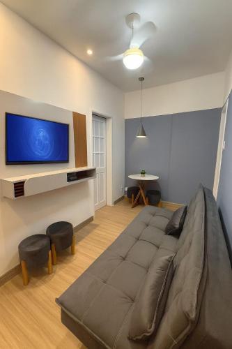 uma sala de estar com uma cama grande e uma televisão em Apartamento no Centro RJ - Rua do Theatro Municipal no Rio de Janeiro