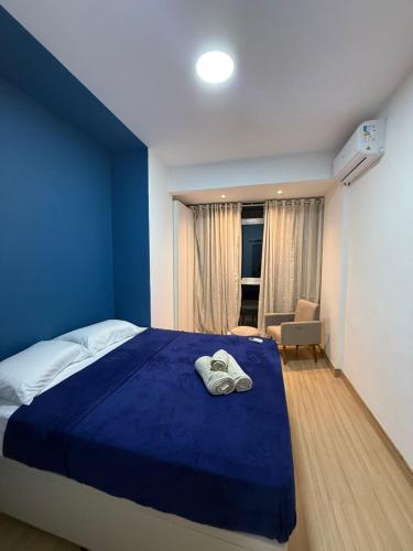 um quarto azul com uma cama e uma cadeira em Apartamento no Centro RJ - Rua do Theatro Municipal no Rio de Janeiro