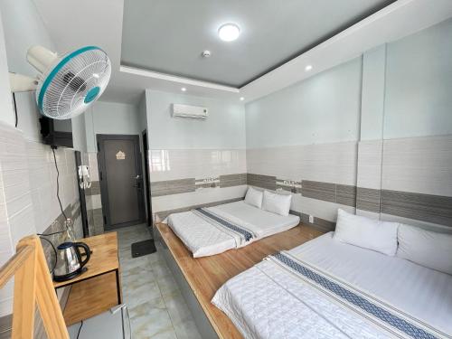 a room with two beds and a fan at Ong 5 Homestay Can Tho in Can Tho