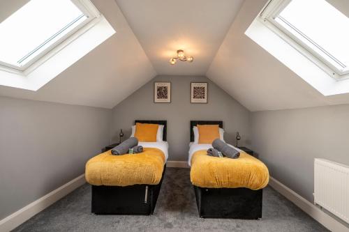 zwei Betten in einem Dachgeschossschlafzimmer mit Dachfenster in der Unterkunft Contractor & Professional Friendly House in Sleaford