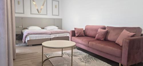 ein Wohnzimmer mit einer Couch, einem Tisch und einem Bett in der Unterkunft VENETIA-Rooms in Biecz
