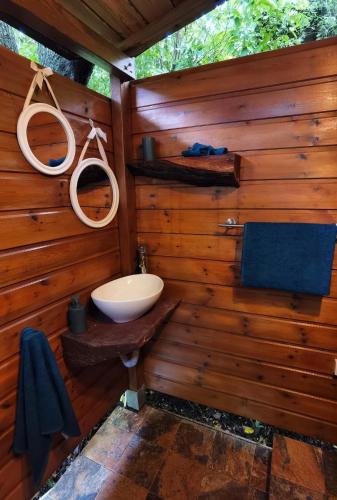 a bathroom with a sink in a wooden wall at Kaz Coco Bungalow in Bouillante