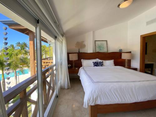 a bedroom with a bed and a view of the ocean at Fortunity Club- Playa Dorada, Pto Plata in Sampiño