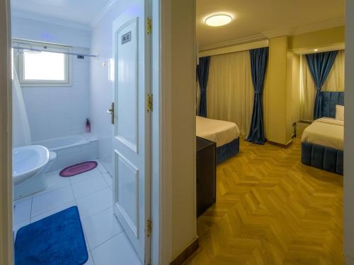 a bathroom with a toilet and a sink and a tub at Villa 53 Hotel Luxury Suites by Pharaohs Hospitality in Sheikh Zayed