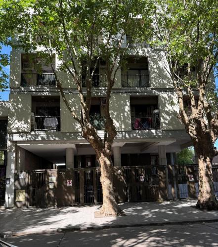a building with two trees in front of it at Escobar Centro in Belén de Escobar