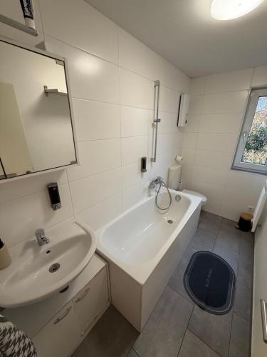 a bathroom with a sink and a tub and a mirror at Monteurzimmer Schölerpad in Essen