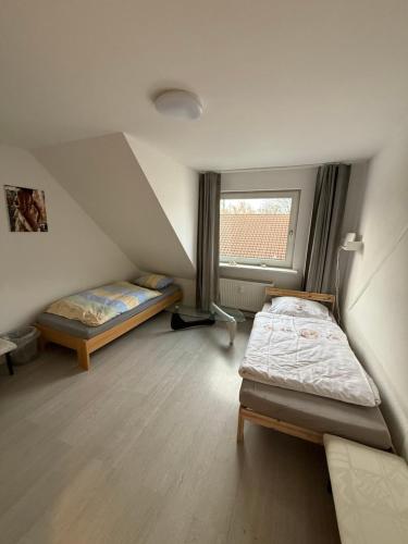 a small room with two beds and a window at Monteurzimmer Schölerpad 24h Self Check in in Essen
