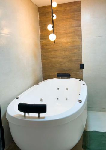 a bath tub with a black chair sitting on it at ECOLETRAS LOFT CONTAINER - SÃO THOMÉ DAS LETRAS Mg in São Thomé das Letras