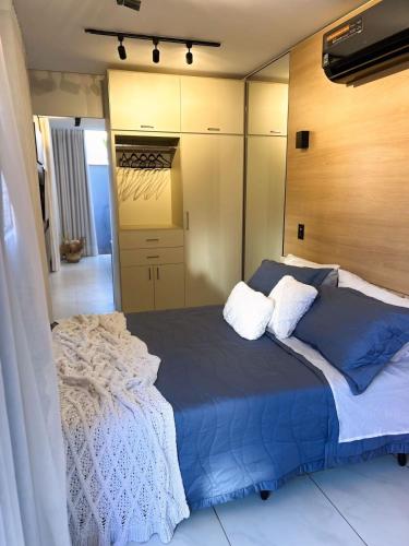 a bedroom with a blue bed and a mirror at ECOLETRAS LOFT CONTAINER - SÃO THOMÉ DAS LETRAS Mg in São Thomé das Letras