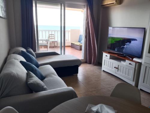 a living room with a couch and a flat screen tv at vistas panoranicas al mar desde su terraza in Moncófar