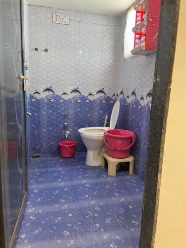 a bathroom with a toilet and a red bucket at Citizen Society, Ellora Park, is very peaceful in Vadodara