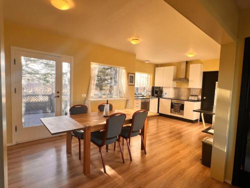 a kitchen and dining room with a table and chairs at Hlíðarból Guesthouse in Hvolsvöllur