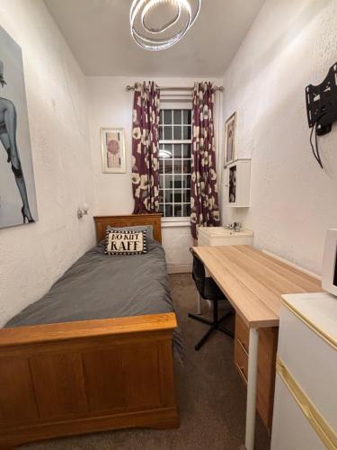 a bedroom with a bed and a desk and a window at Croft Guest House in South Shields