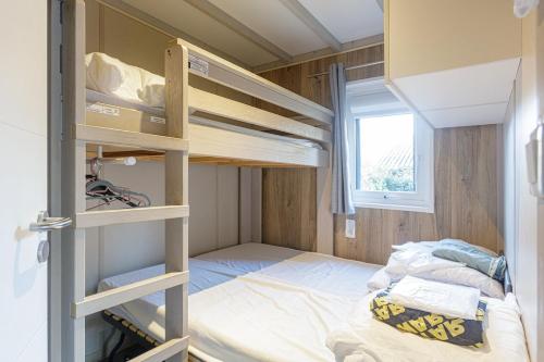 ein kleines Zimmer mit Etagenbetten und einem Bett in der Unterkunft Chalet 809 tout confort en lisière de forêt in La Teste-de-Buch