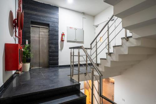 einen Flur mit Treppen und einem Feuerlöscher in der Unterkunft Hotel Travana Stay at Pitampura in Neu-Delhi
