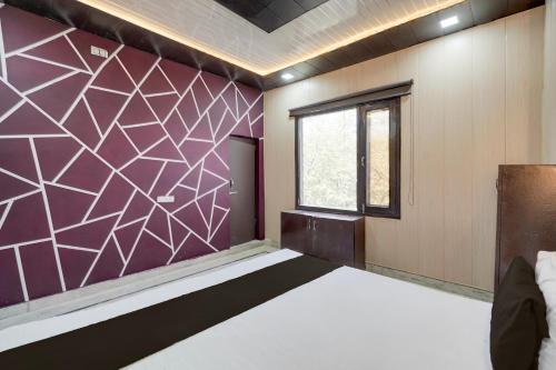 a bedroom with a bed and a purple wall at SPOT ON Sokoon Home Stay in Morādābād