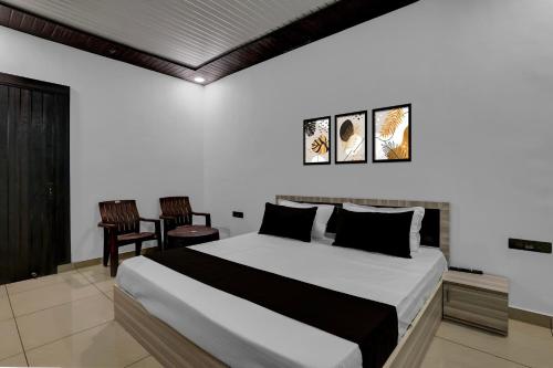 MurādnagarにあるHotel O Sukoon Guest Houseの大きなベッドと椅子2脚のある寝室