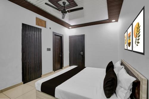 MurādnagarにあるHotel O Sukoon Guest Houseのベッドと天井扇風機のある寝室