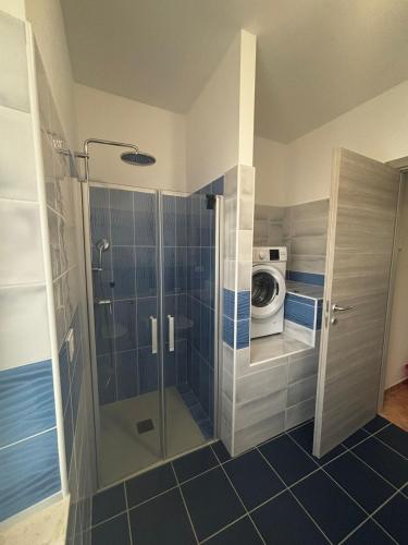 a bathroom with a shower and a washing machine at Elegante bilocale a due passi dal centro in Saluggia