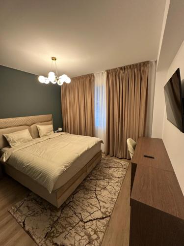 une chambre avec un lit, une télévision et une table dans l'établissement Pipera Luxury Suite - Victoria Homes, à Voluntari