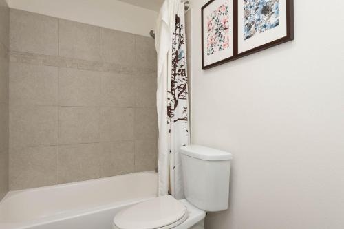 a bathroom with a toilet and a tub and a shower at Hollywood Luxe 2BR Apartment with Rooftop Pool and Breathtaking Views in Los Angeles