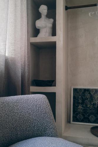 a room with a couch and a statue on a shelf at L'Ulivo e il Melograno - Mediterranean Studios in Frattamaggiore