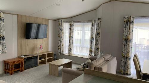 a living room with a couch and a tv at Grahams Lodge in Tydd Saint Giles