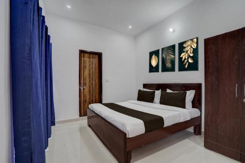 une chambre avec un grand lit avec des rideaux bleus dans l'établissement Hotel O SGT University Road Formerly Budhera, à Dhankot