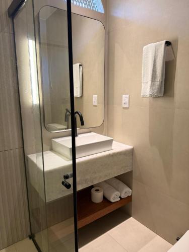 a bathroom with a sink and a mirror at Pousada Macamirim in Macaíba