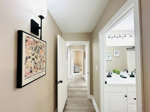 a hallway with a bathroom with a sink and a mirror at Eastgate 9A Beautiful Townhouse in Hammond