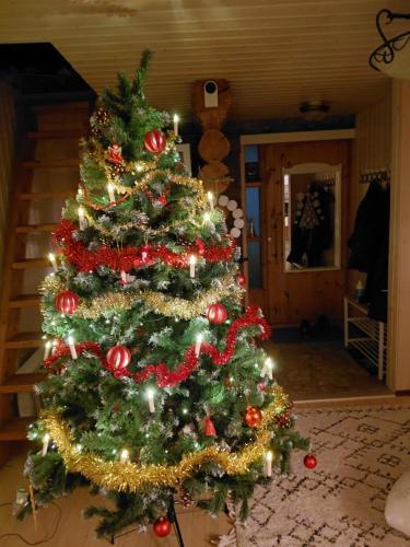 a christmas tree with ornaments on it in a room at A room (or 2 or 3) in a Lapland House of Dreams in Rovaniemi