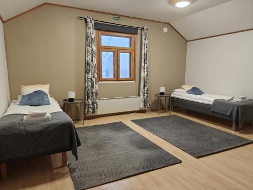 una camera da letto con due letti e una finestra di Spacious Apartment for 12 with Sauna a Laitasaari