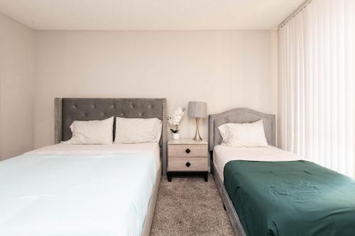 a bedroom with two beds next to a window at 2BR Hollywood Apt with Rooftop Pool & Stunning Views in Los Angeles