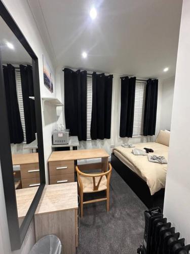 a bedroom with a bed and a desk and a mirror at Shard View Room central London in London