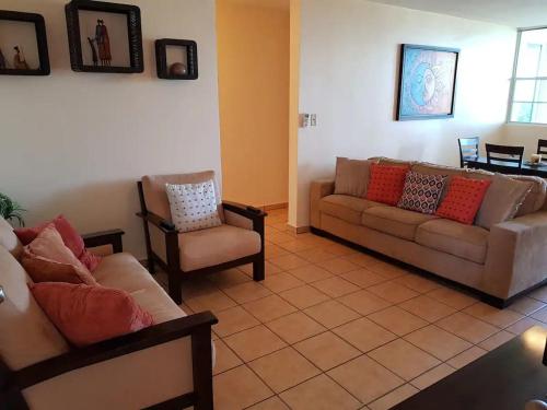 a living room with two couches and a chair at Gated Complex with Pool Balcony Near Attractions in Pole Ojea